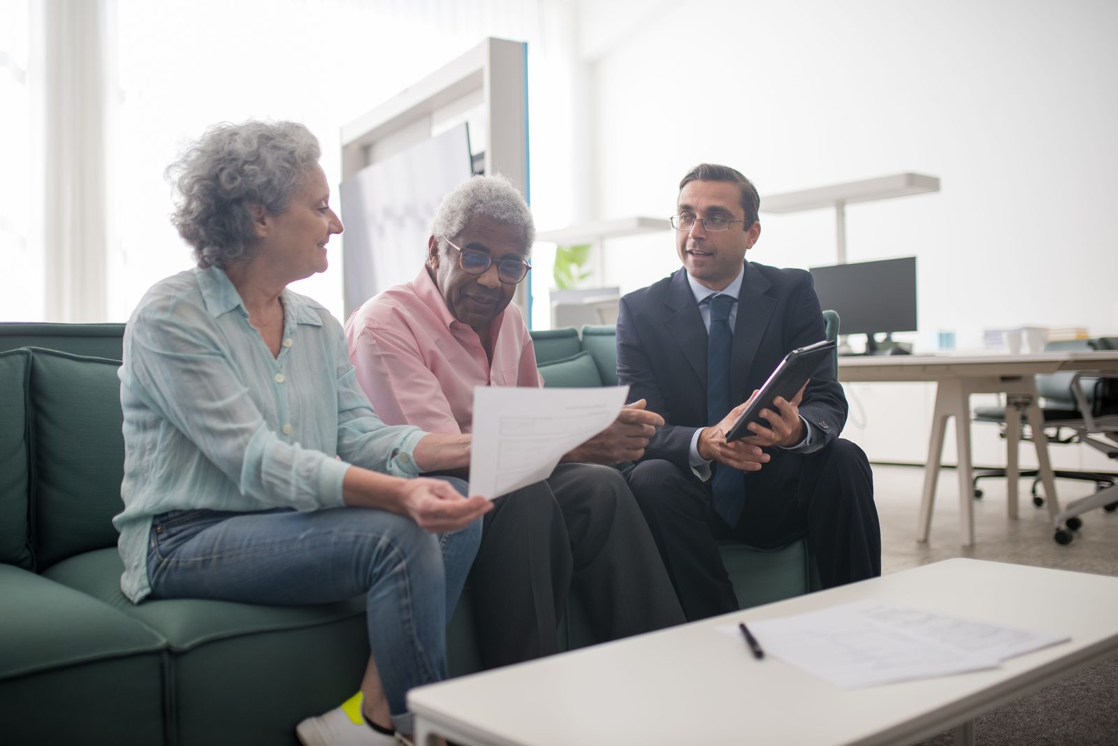 Older clients reviewing financial documents with an advisor