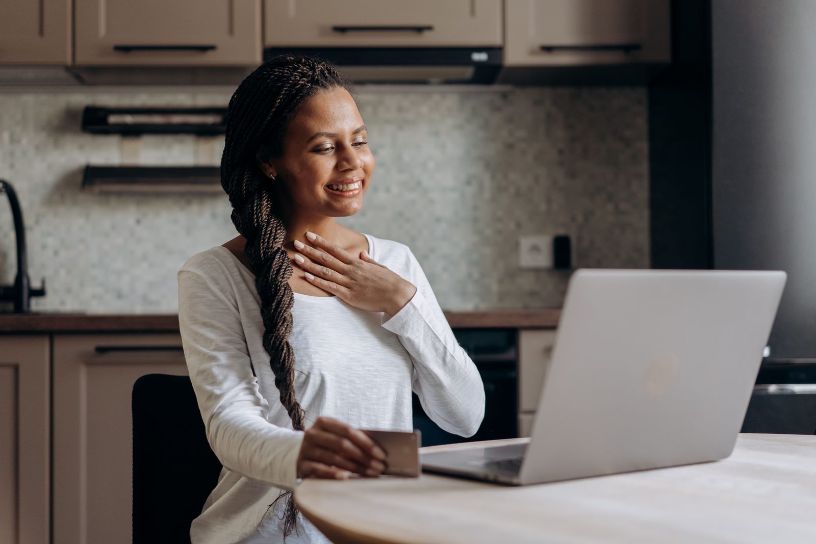 Consumer using a laptop and payment card at home