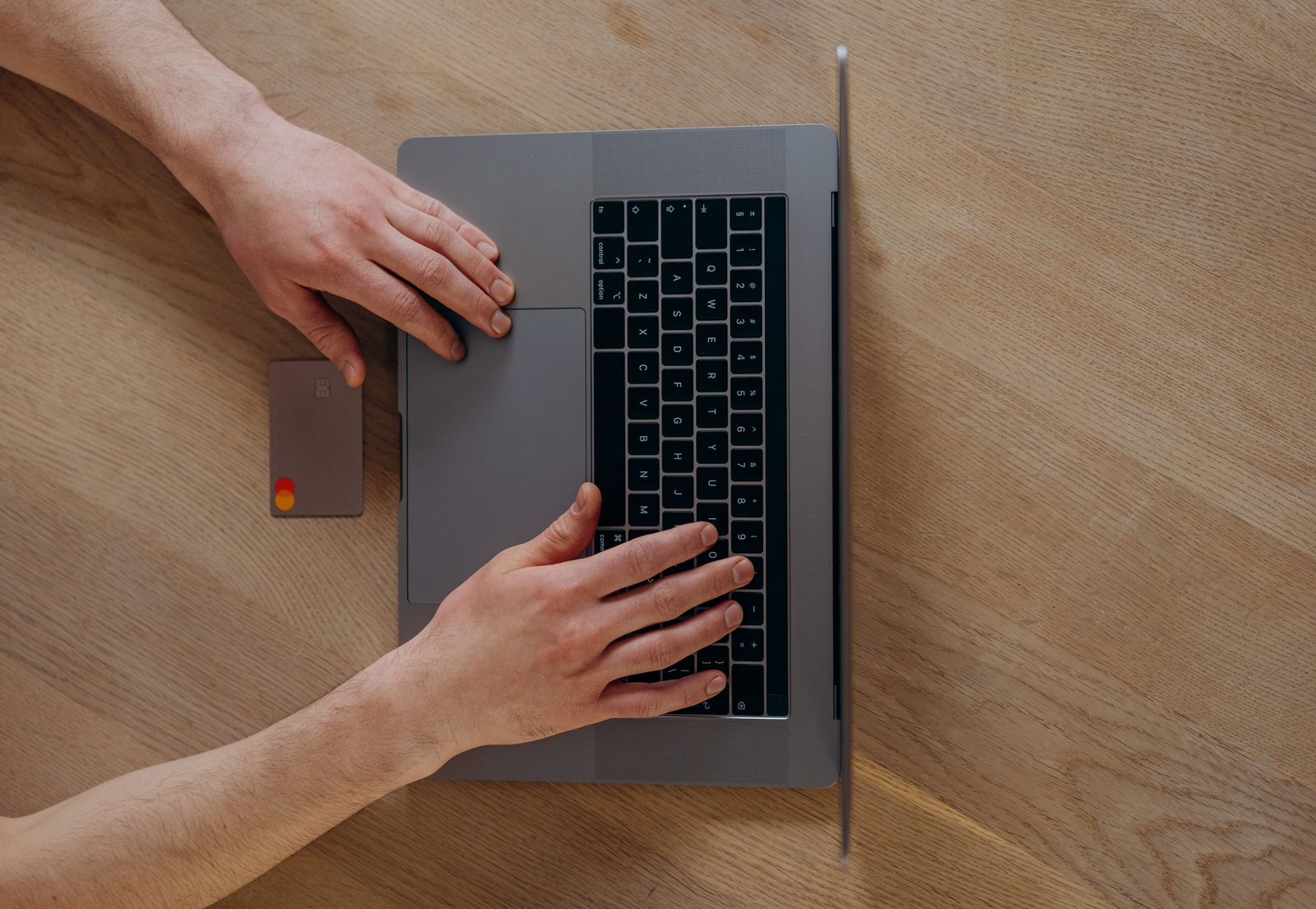 Laptop and payment card on a wooden desk
